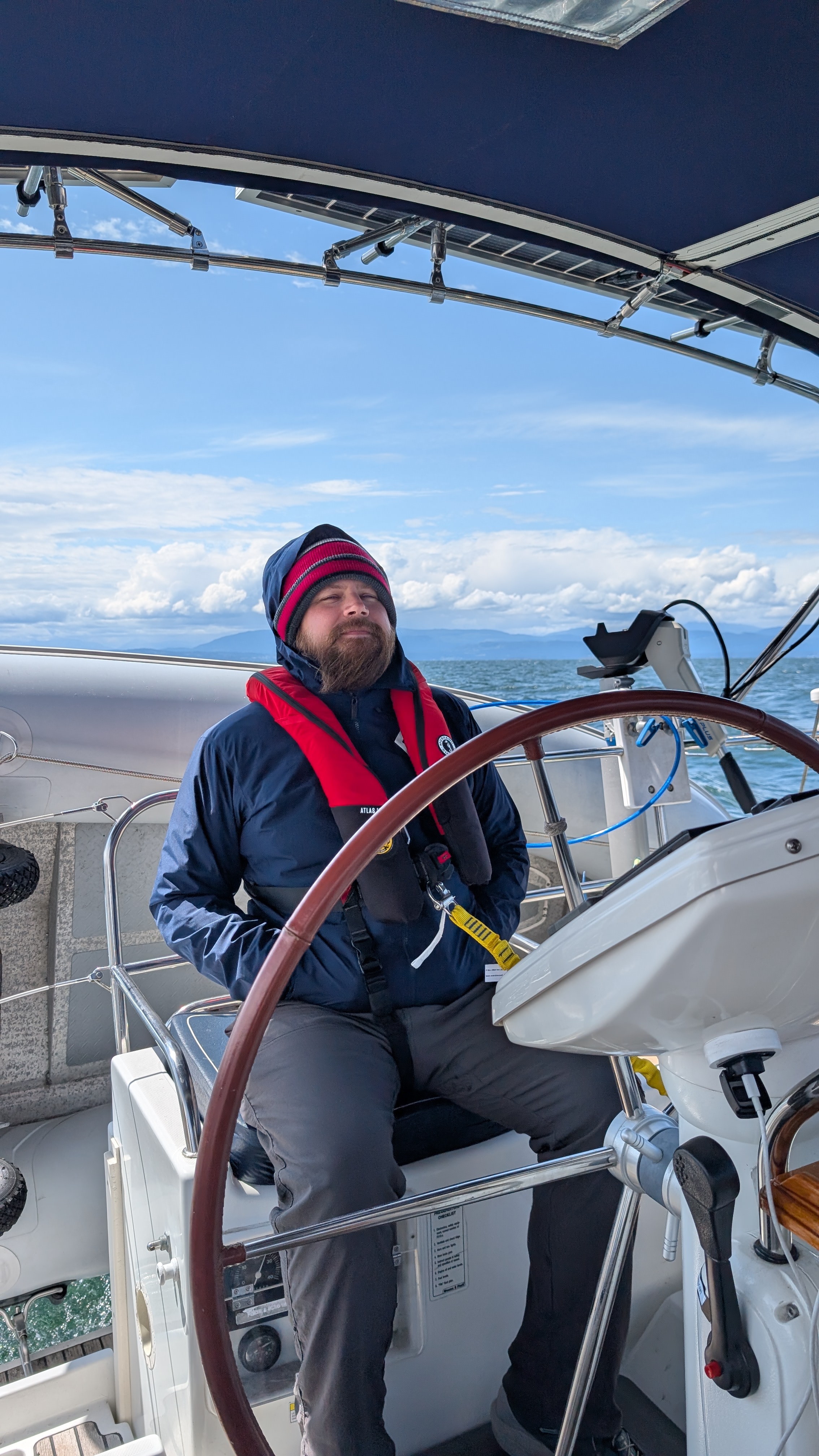 Brian bundled up at the helm in foul weather gear crossing the Strait of Georgia