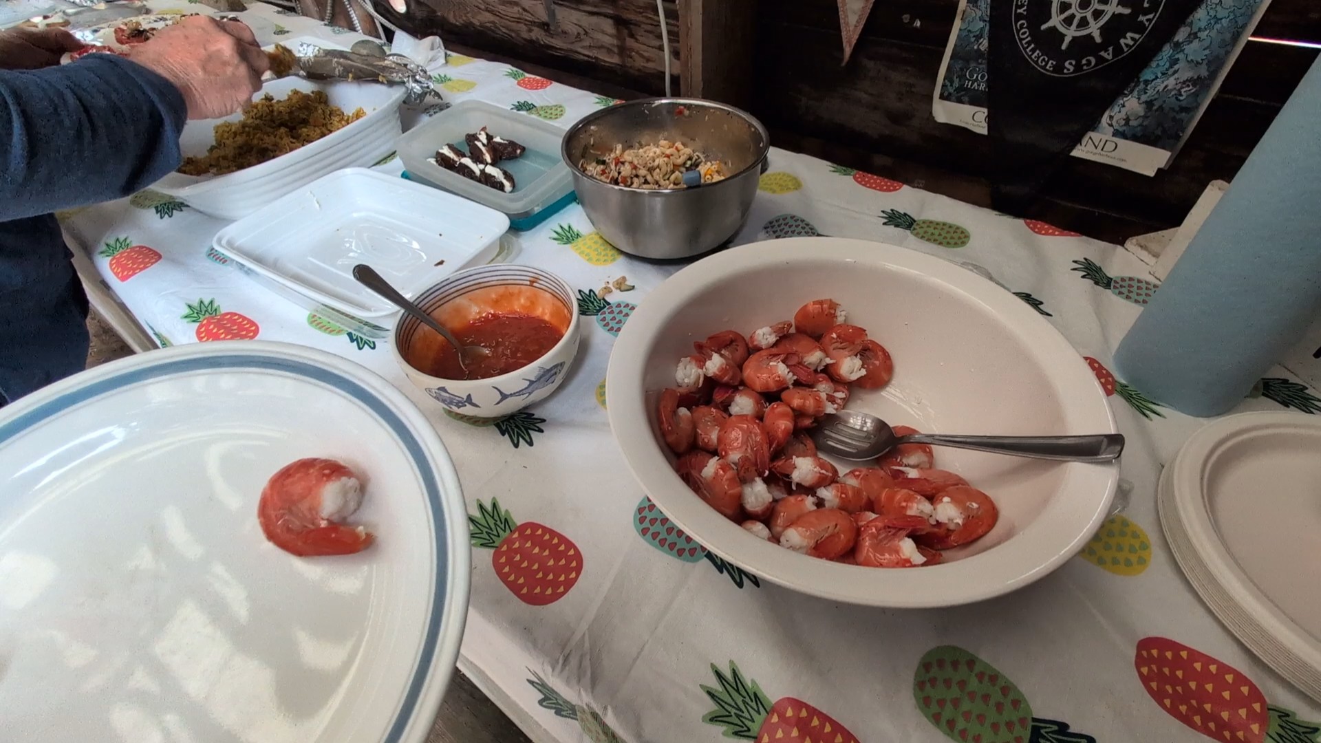 Potluck food spread with tomato salad, cookies, and pasta at Lagoon Cove