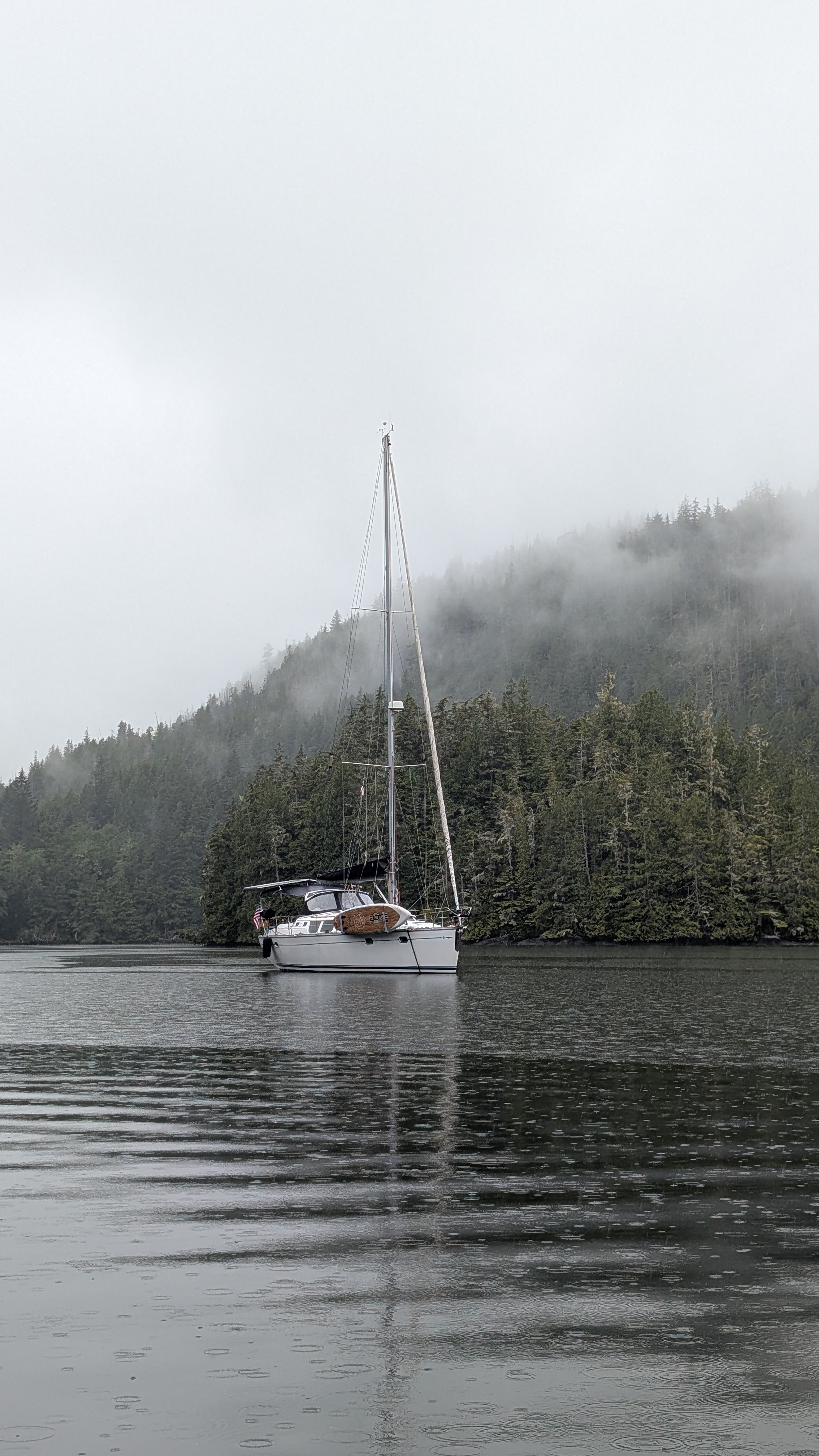 SV Yahara anchored alone in misty Waddington Bay with fog-covered mountains