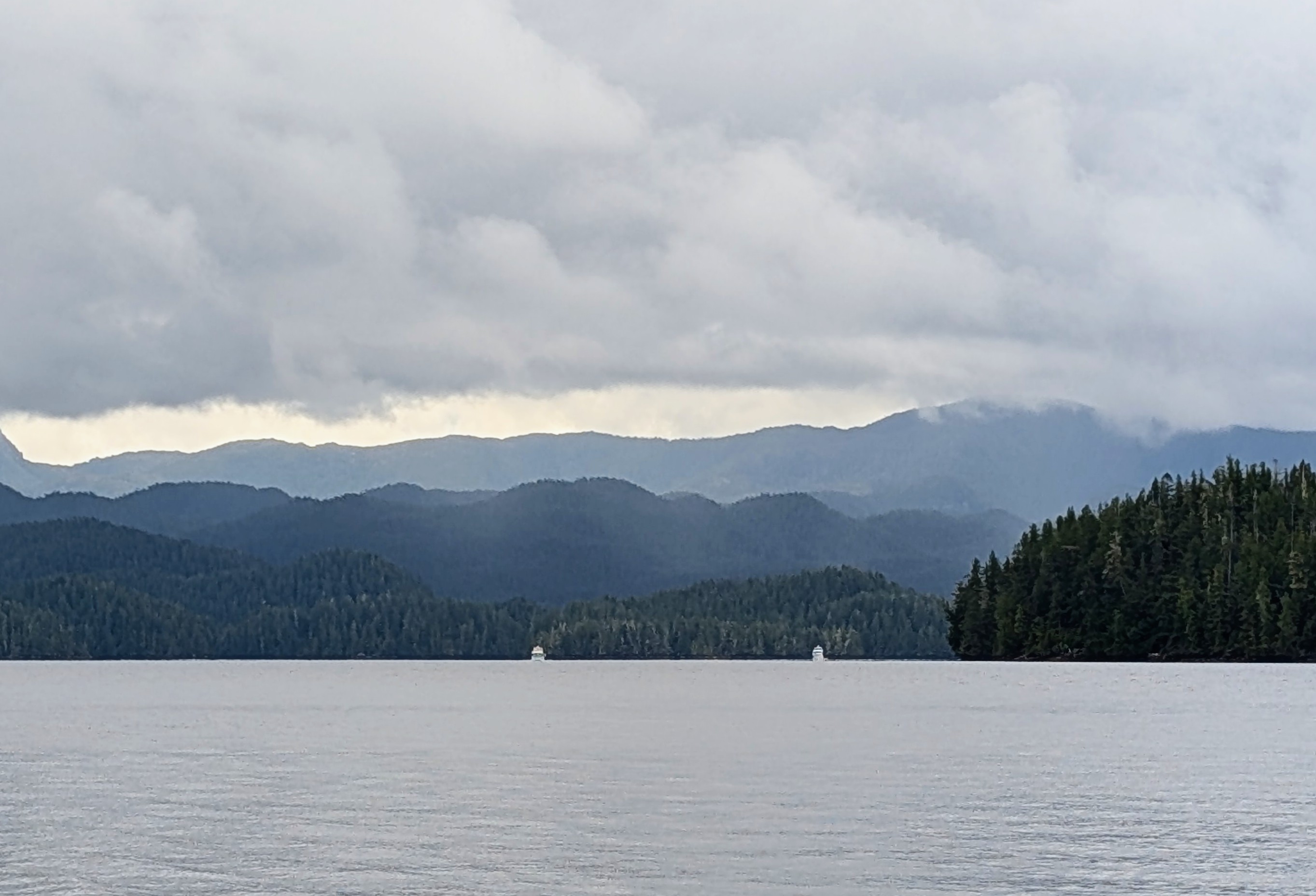 Layered misty mountains and calm waters on the passage to Pruth Bay