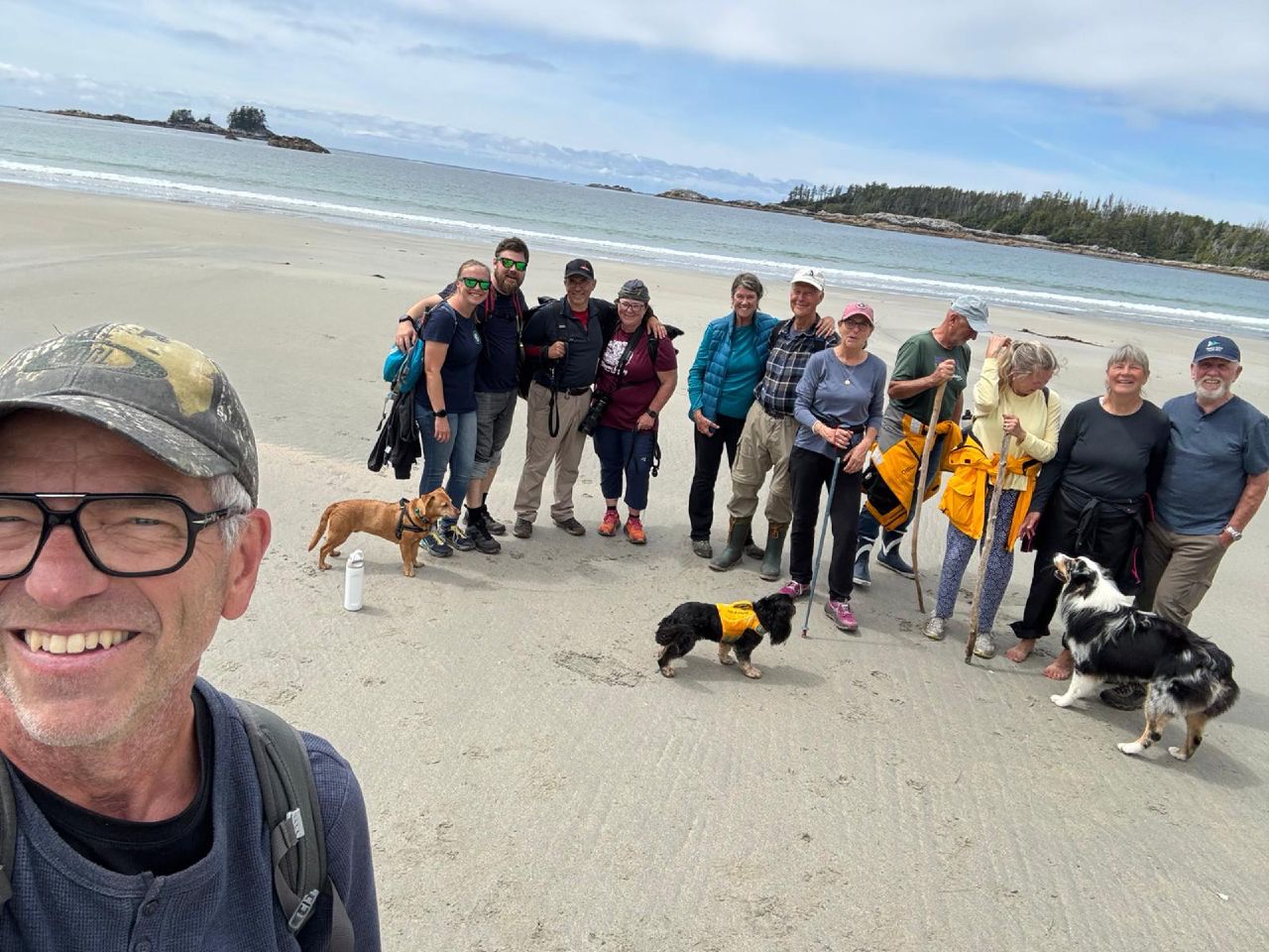 Group selfie with the hiking crew and dogs on the sandy beach at Pruth Bay
