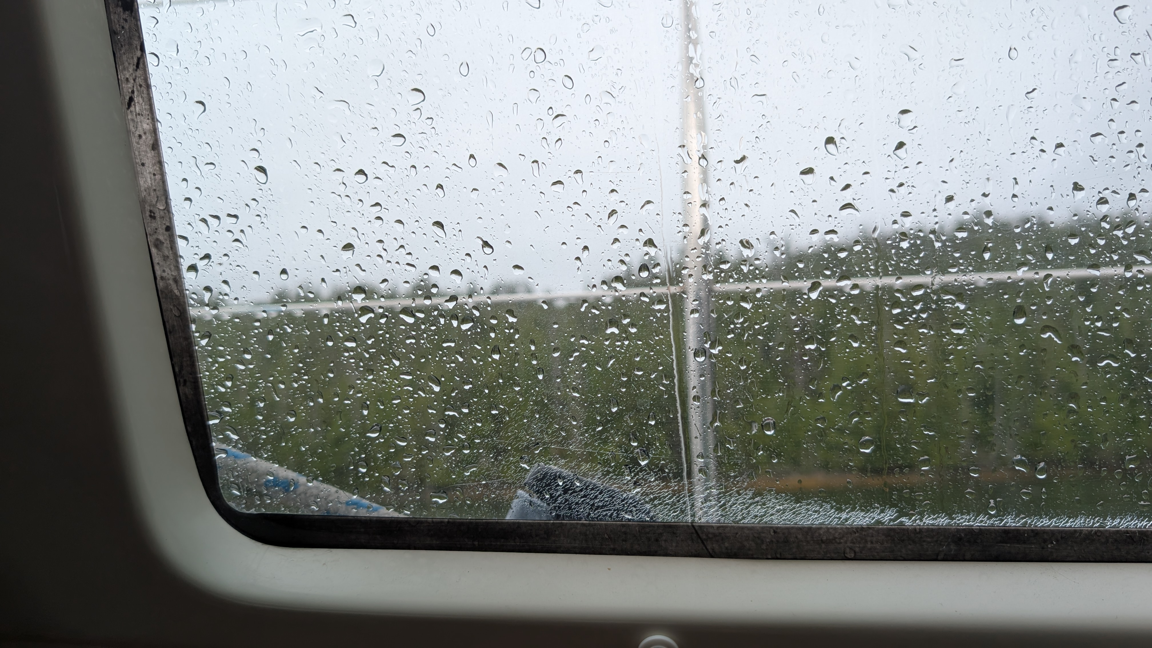 Raindrops covering the porthole window of the sailboat on a rainy day at Rock Inlet
