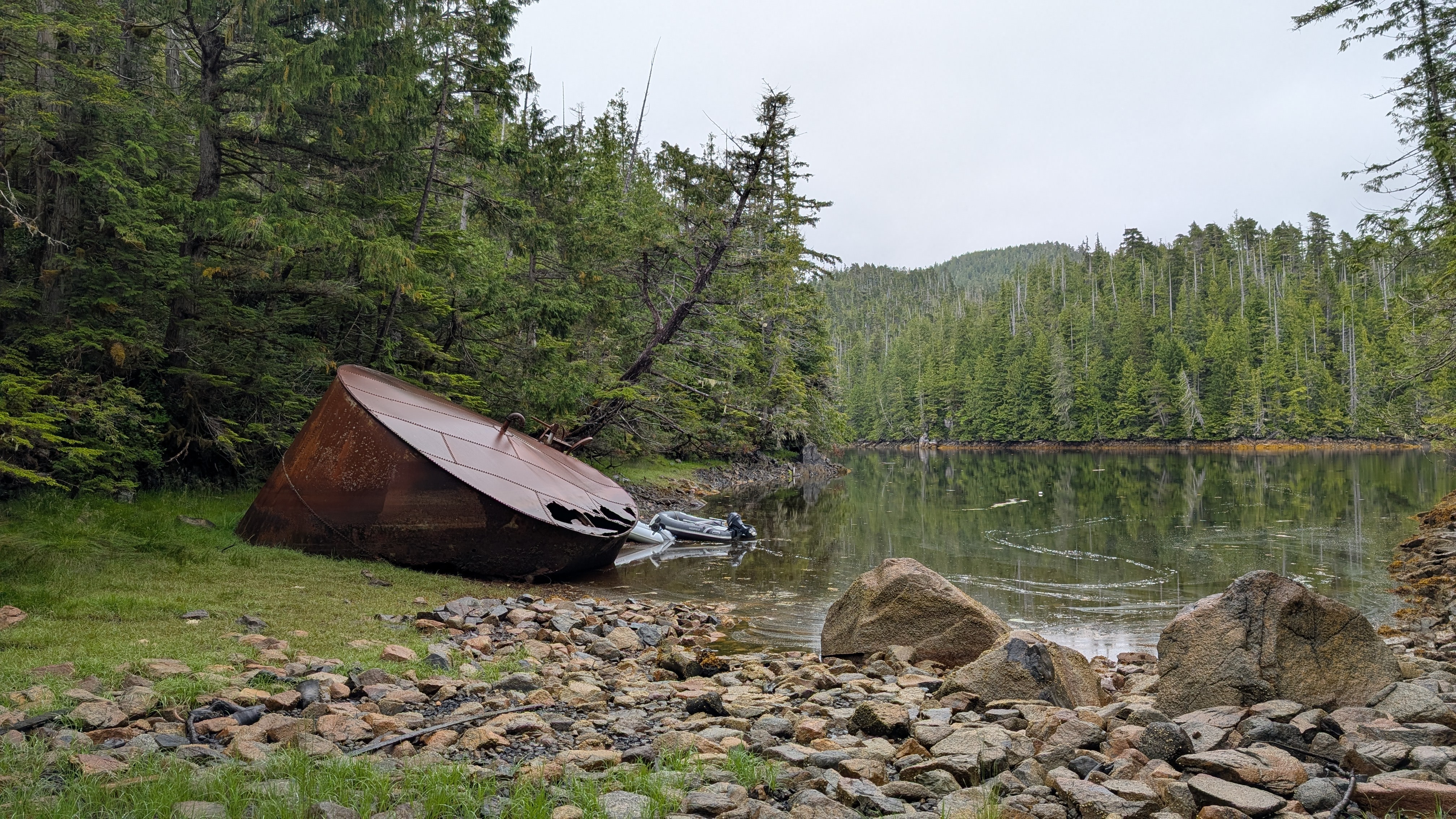 Large rusty boiler relic washed up on the rocky shore at Rock Inlet