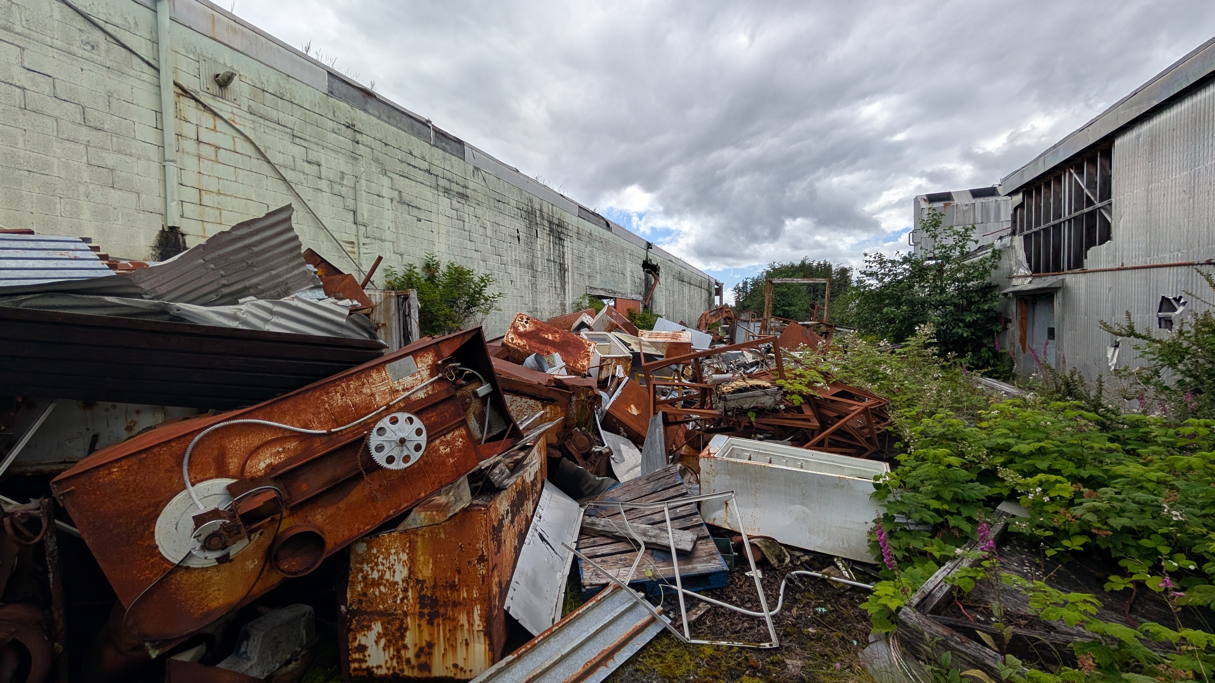 Pile of rusty machinery and industrial debris outside the abandoned Namu cannery