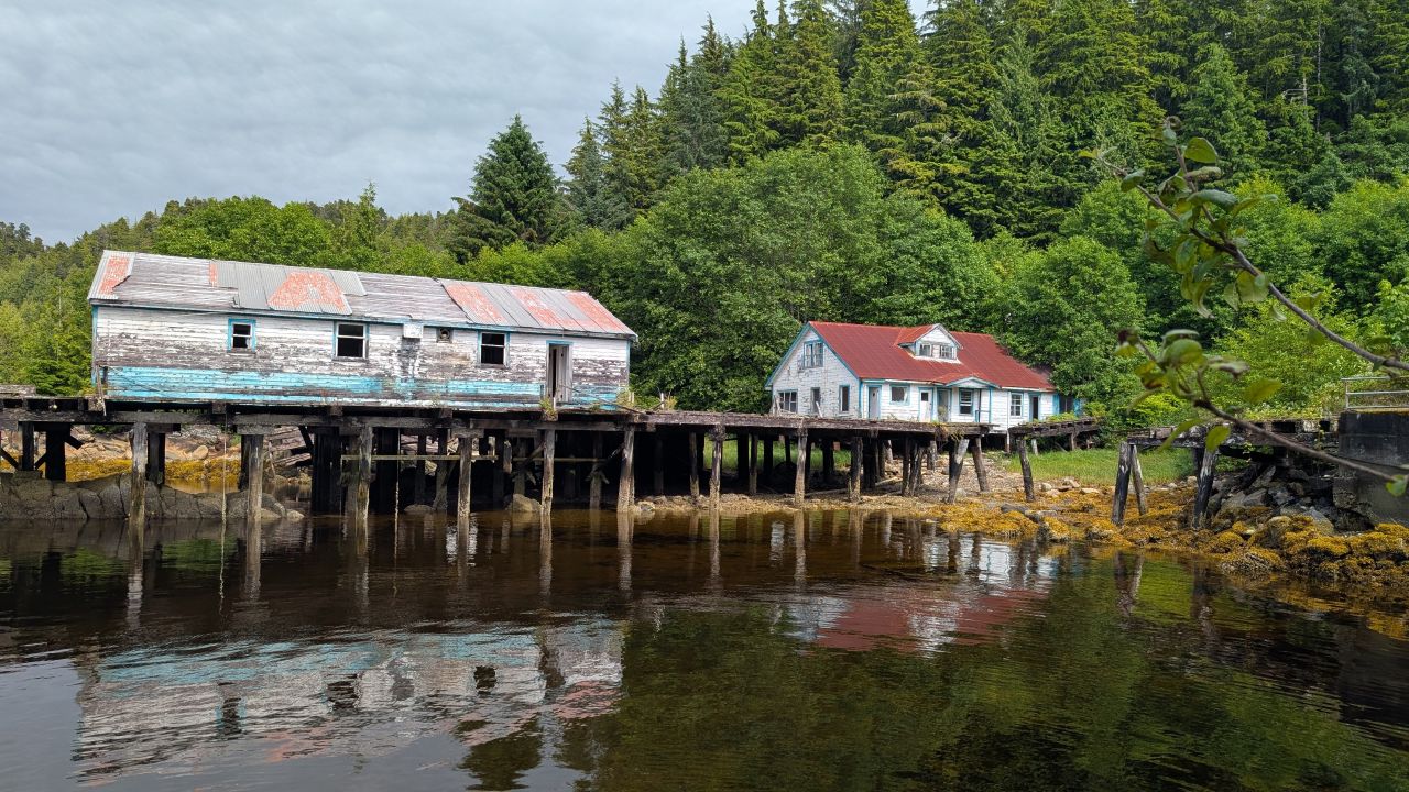 Weathered buildings on wooden stilts over the water at the abandoned town of Namu
