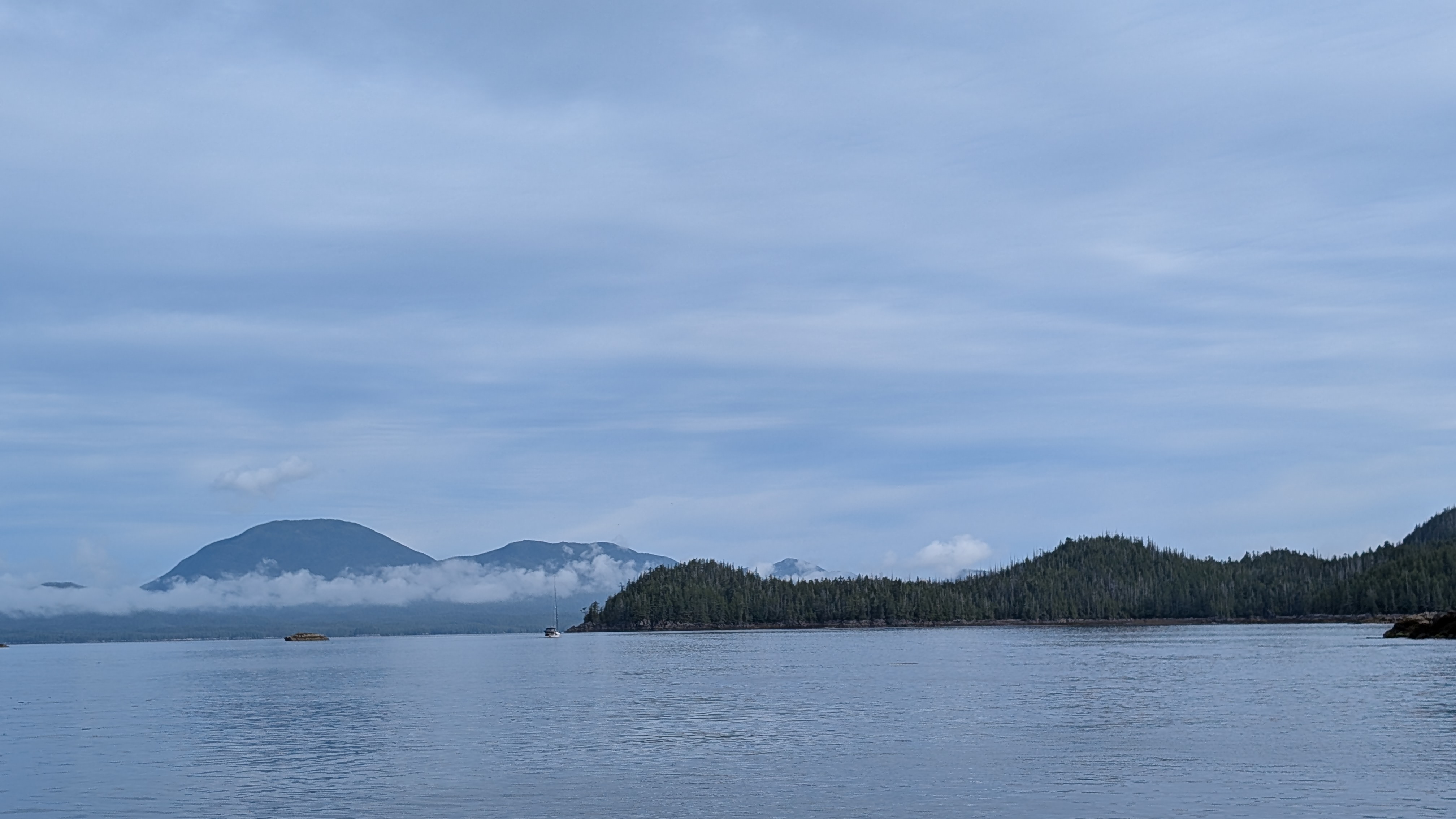 Calm water with misty mountains and low clouds on the passage to Codville Lagoon