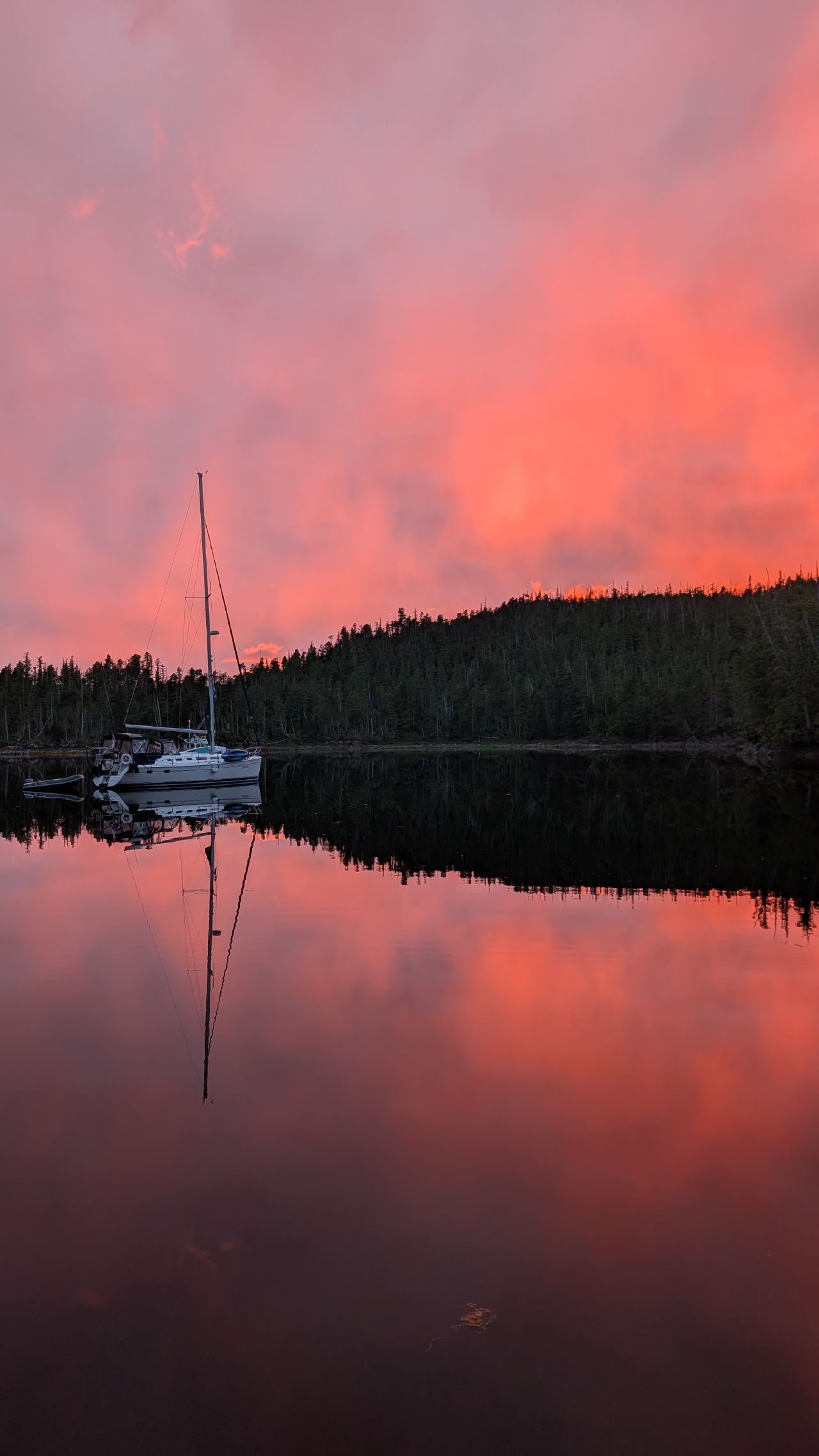 Stunning red sky at night with SV Yahara anchored on glassy water reflecting the sunset