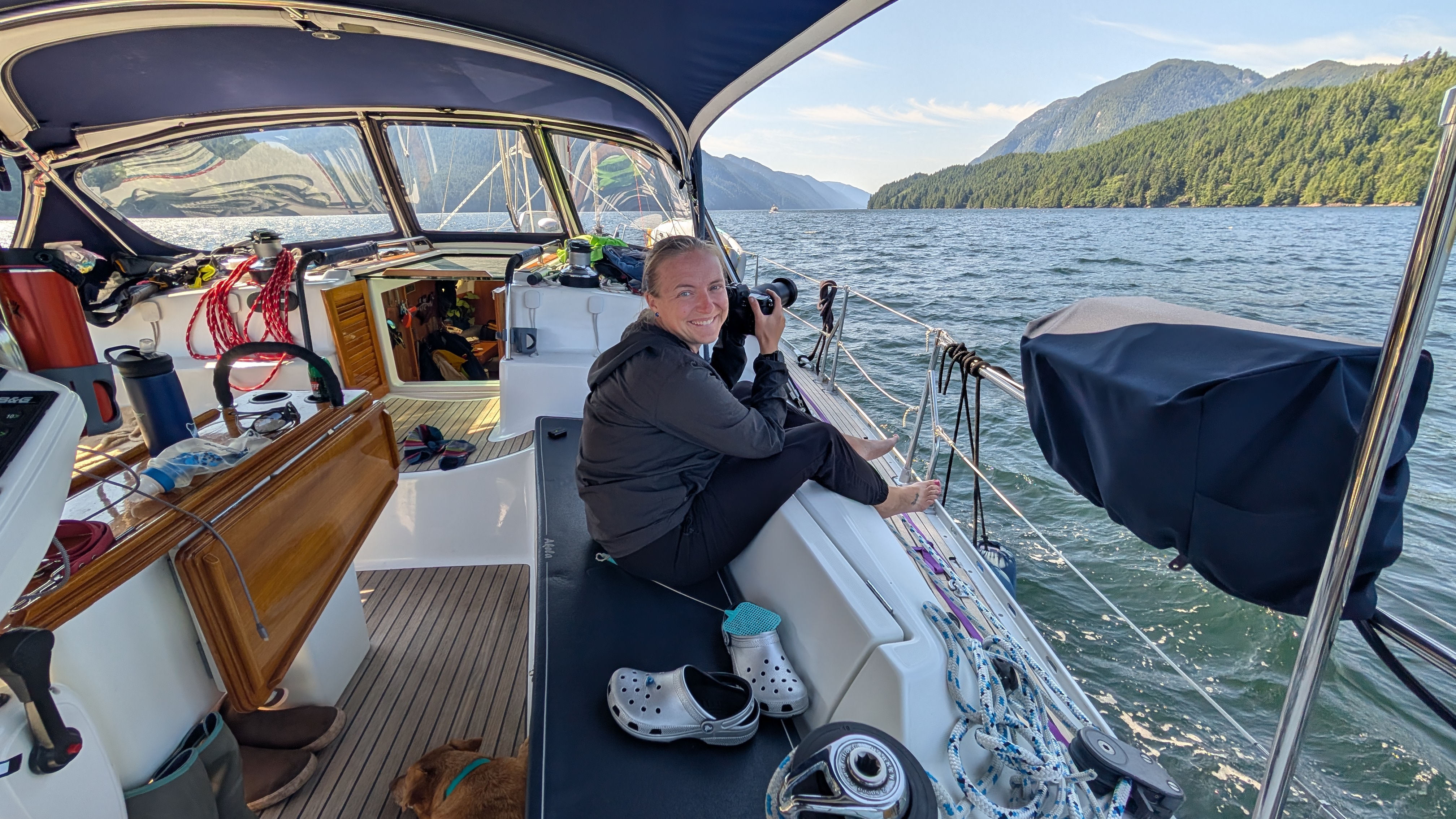 Rachel smiling with her camera in the cockpit, ready to photograph humpback whales on the passage to Butedale