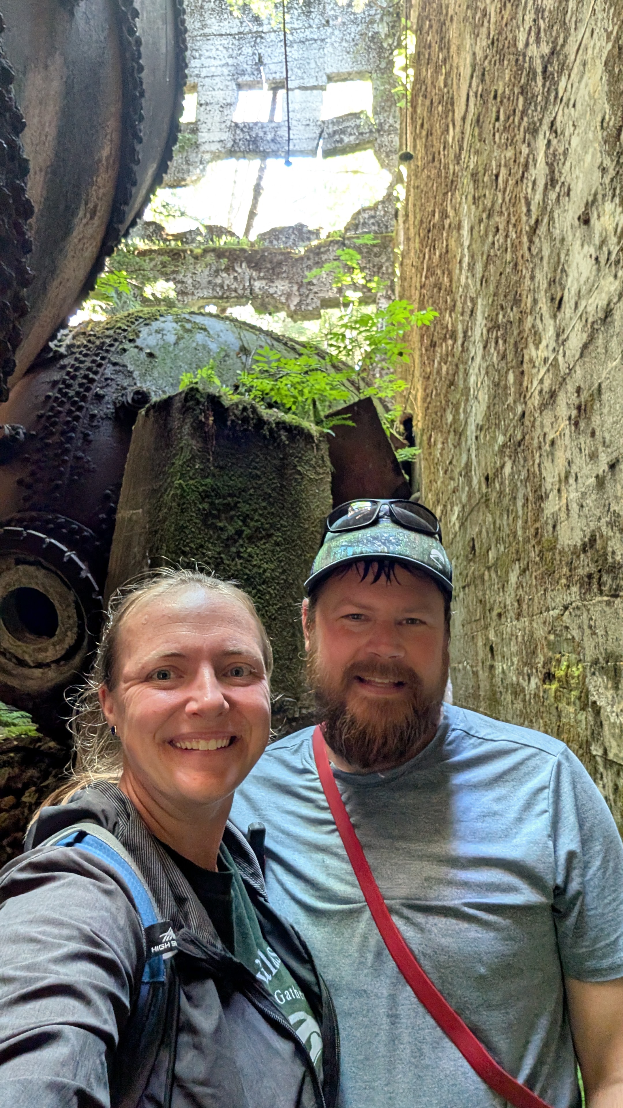 Rachel and Brian selfie surrounded by rusted industrial machinery at the Swanson Bay ruins