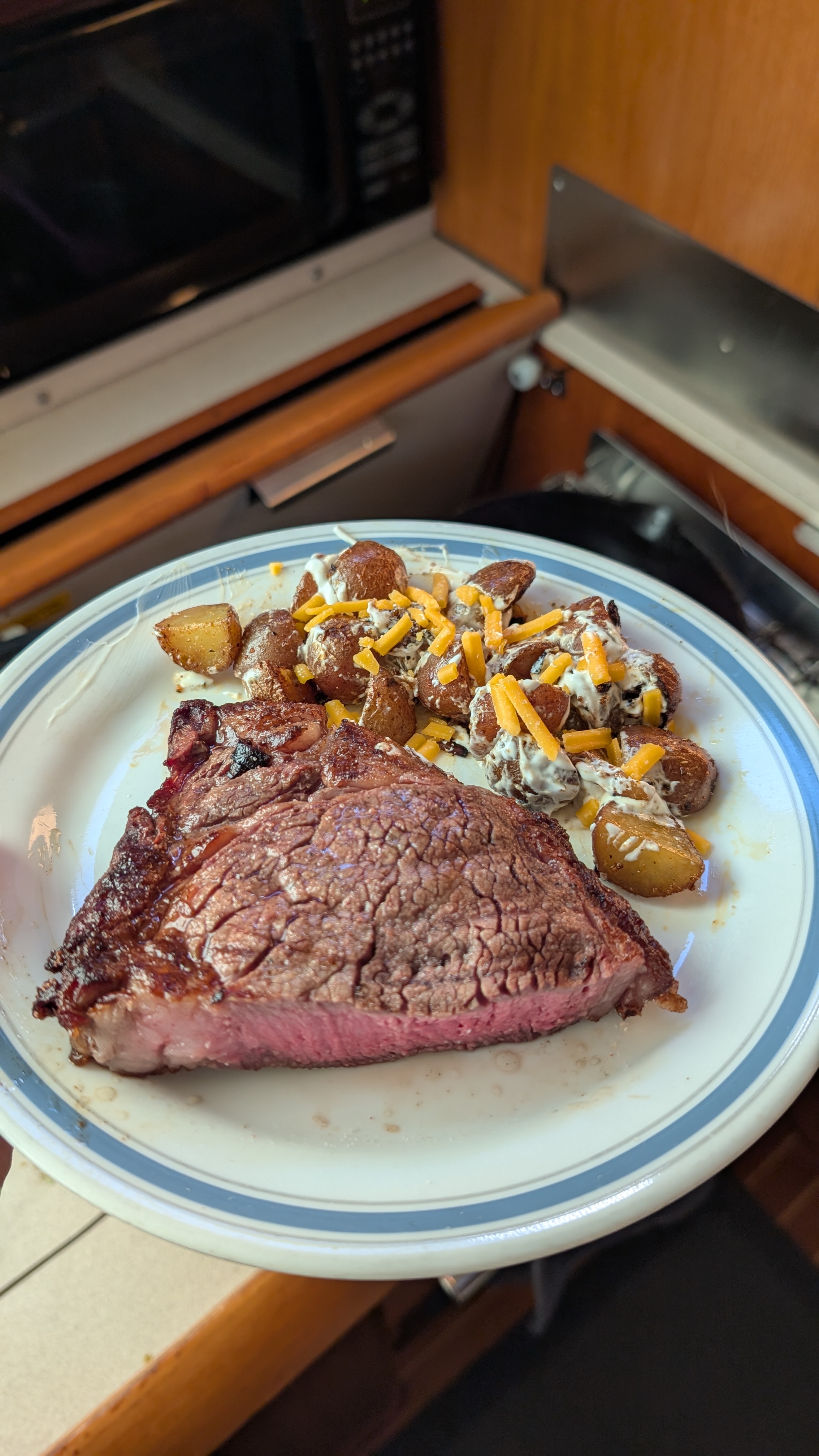 Seared steak with loaded potatoes and cheese dinner made in the boat galley