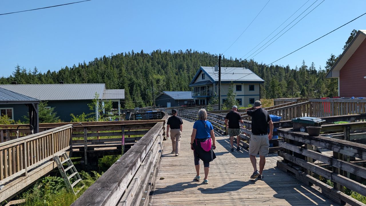 Flotilla crew walking along the elevated boardwalk through Hartley Bay village