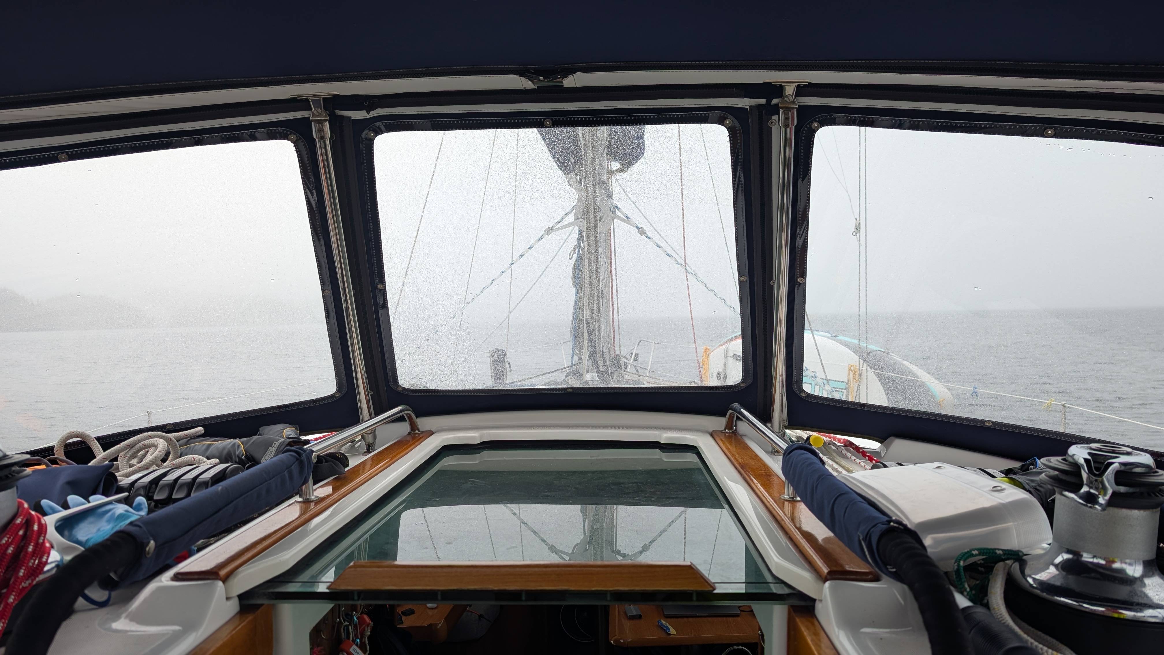 Foggy view forward through the rain-splattered dodger windows during the passage