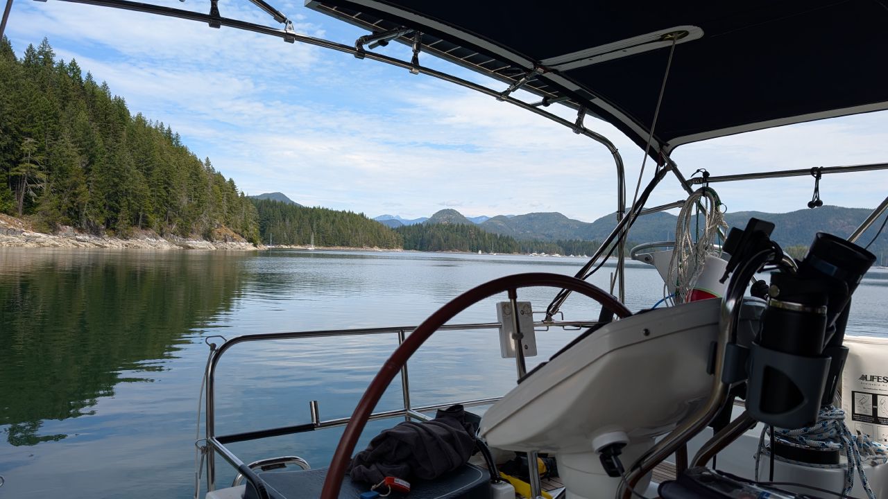 View from the cockpit of SV Yahara arriving at Octopus Islands anchorage with mountains and calm water