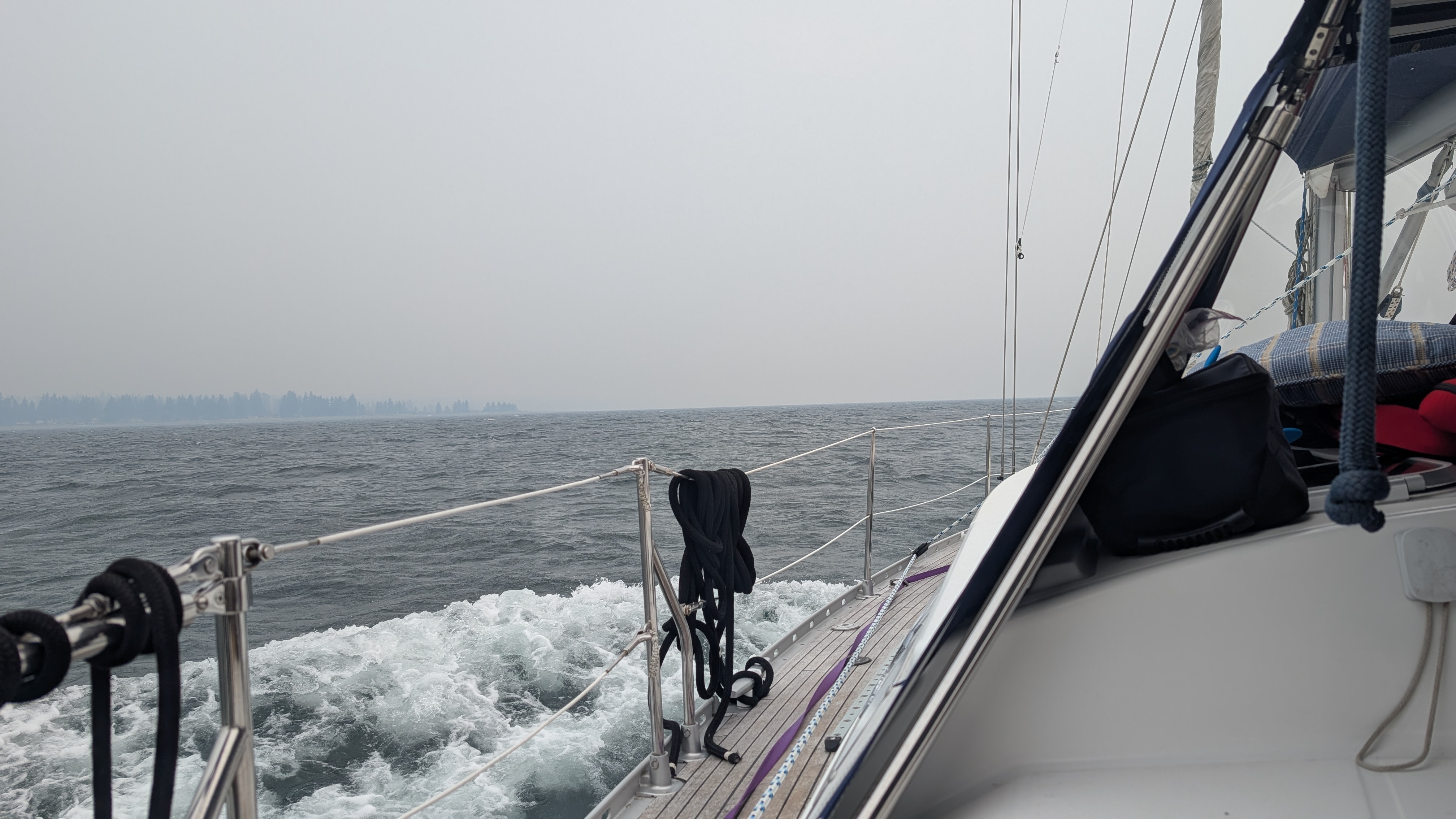 Rough seas and heavy spray along the deck of SV Yahara in 25-knot winds and smoky skies heading to Comox