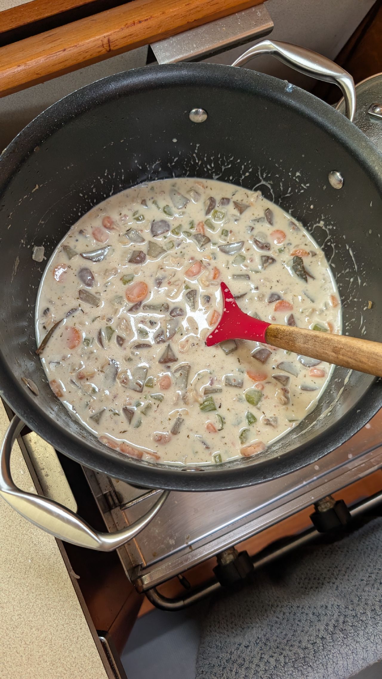 Pot of homemade clam chowder cooking on the boat stove made from freshly foraged clams at Henry Bay