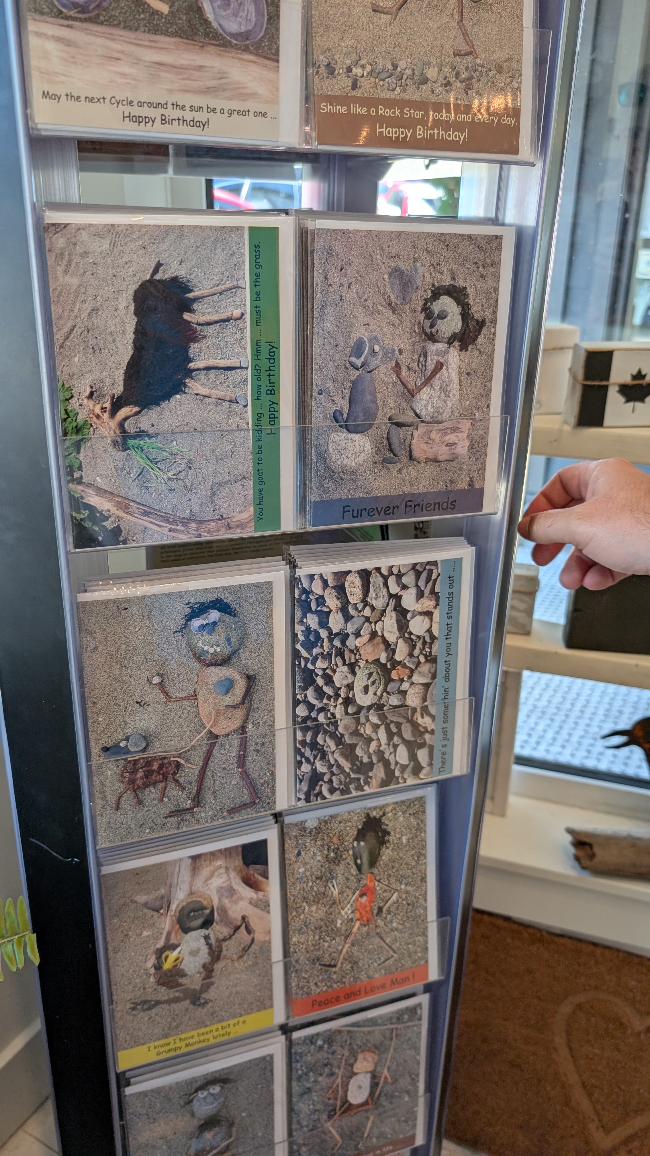 Display rack of locally made art cards with whimsical rock and driftwood designs at the Ladysmith makers market