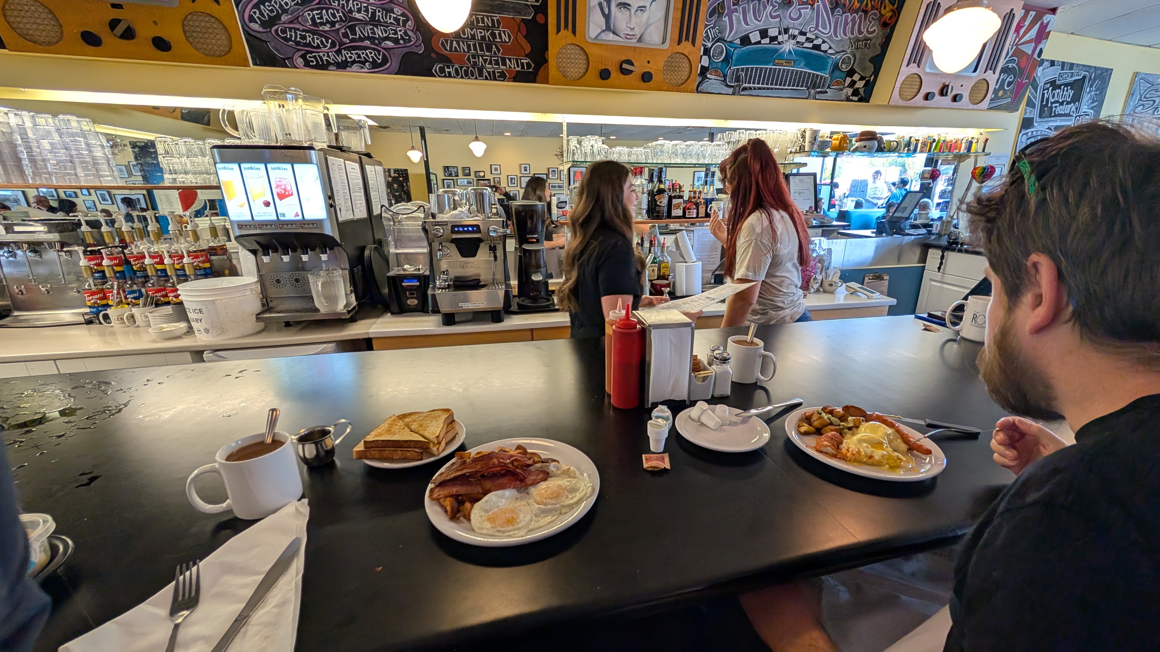 Breakfast plates with eggs, bacon, and toast at the Five and Dime Diner counter in Sidney