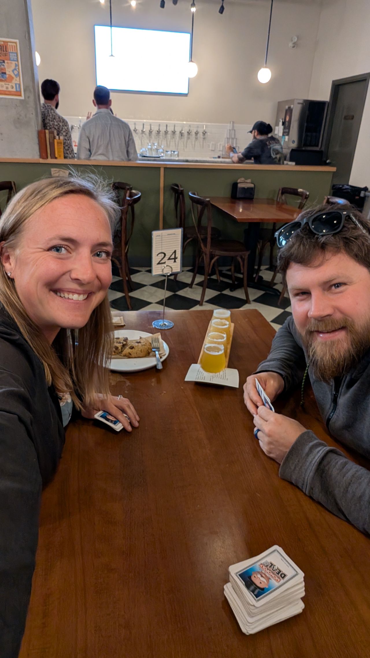 Rachel and Brian playing cards with beer flights at a brewery in Sidney