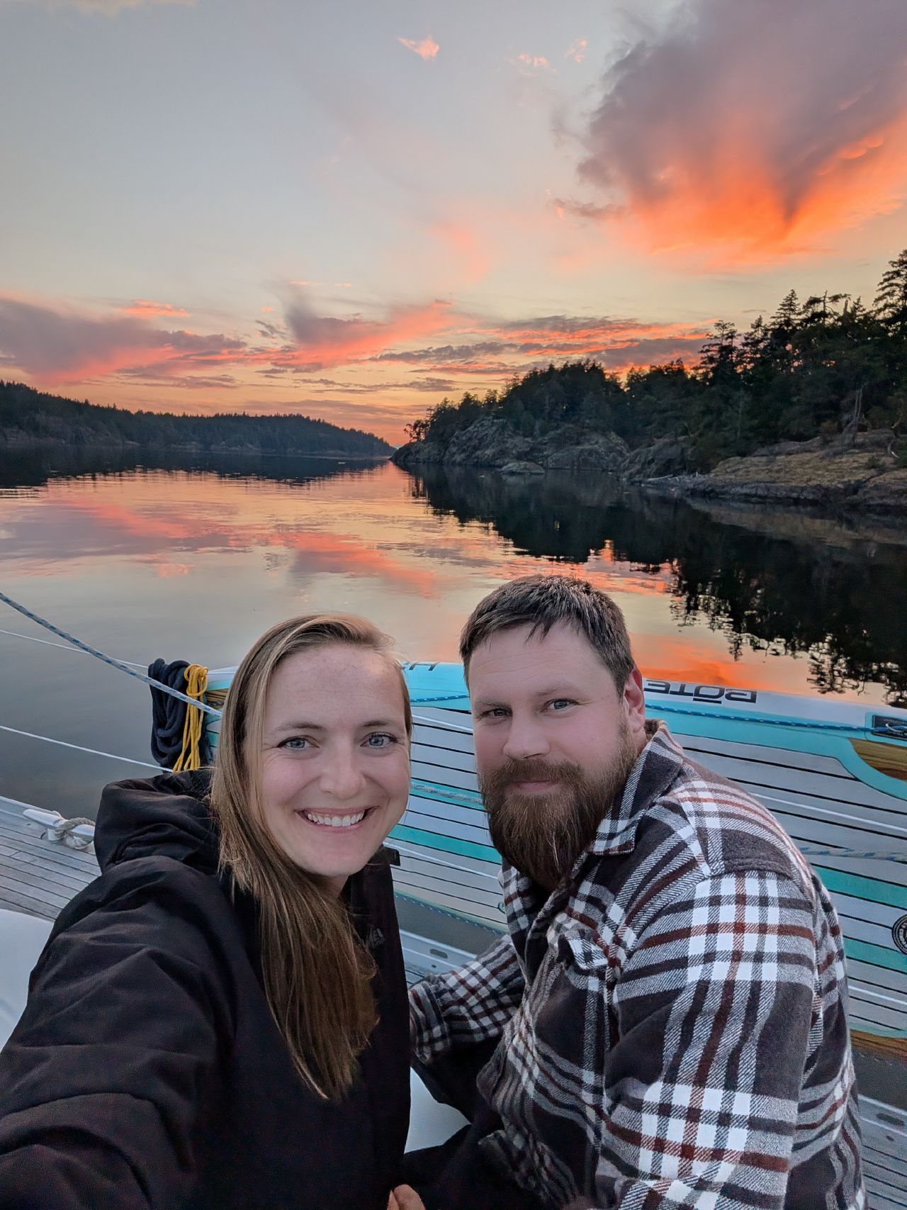 44% 62% Rachel and Brian smiling for a selfie at a fiery sunset, anchored at Jedediah Island